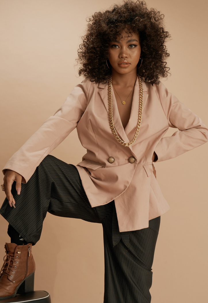 Curly-Haired Woman Wearing a Beige Suit Jacket